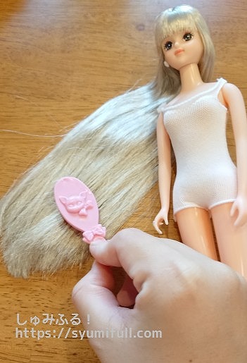 人形の髪をクシでとかす